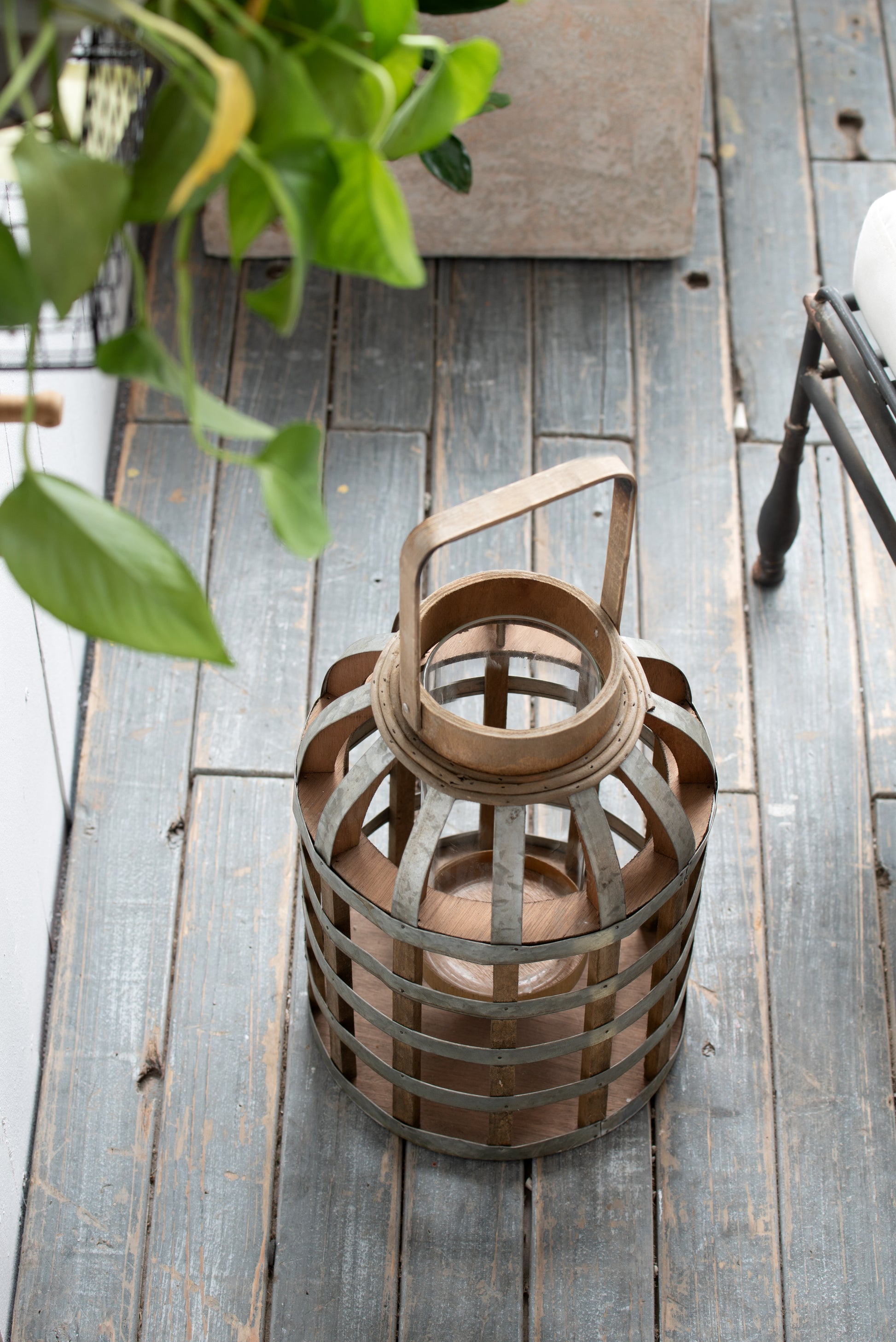 Rustic wooden and metal lantern with glass cylinder ideal for outdoor ambiance