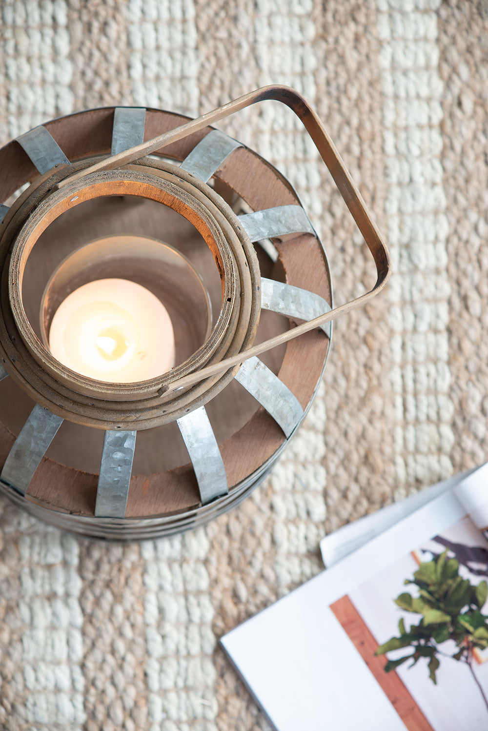 Rustic wooden lantern with metal bands and a lit candle