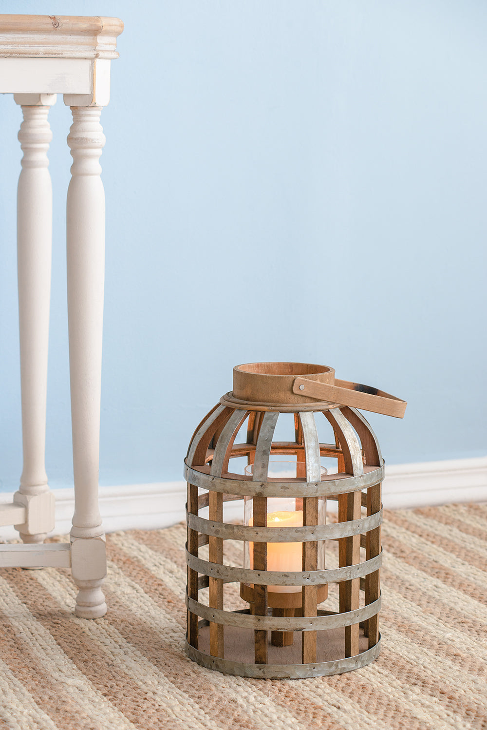 Rustic wooden and metal caged lantern with lit candle inside