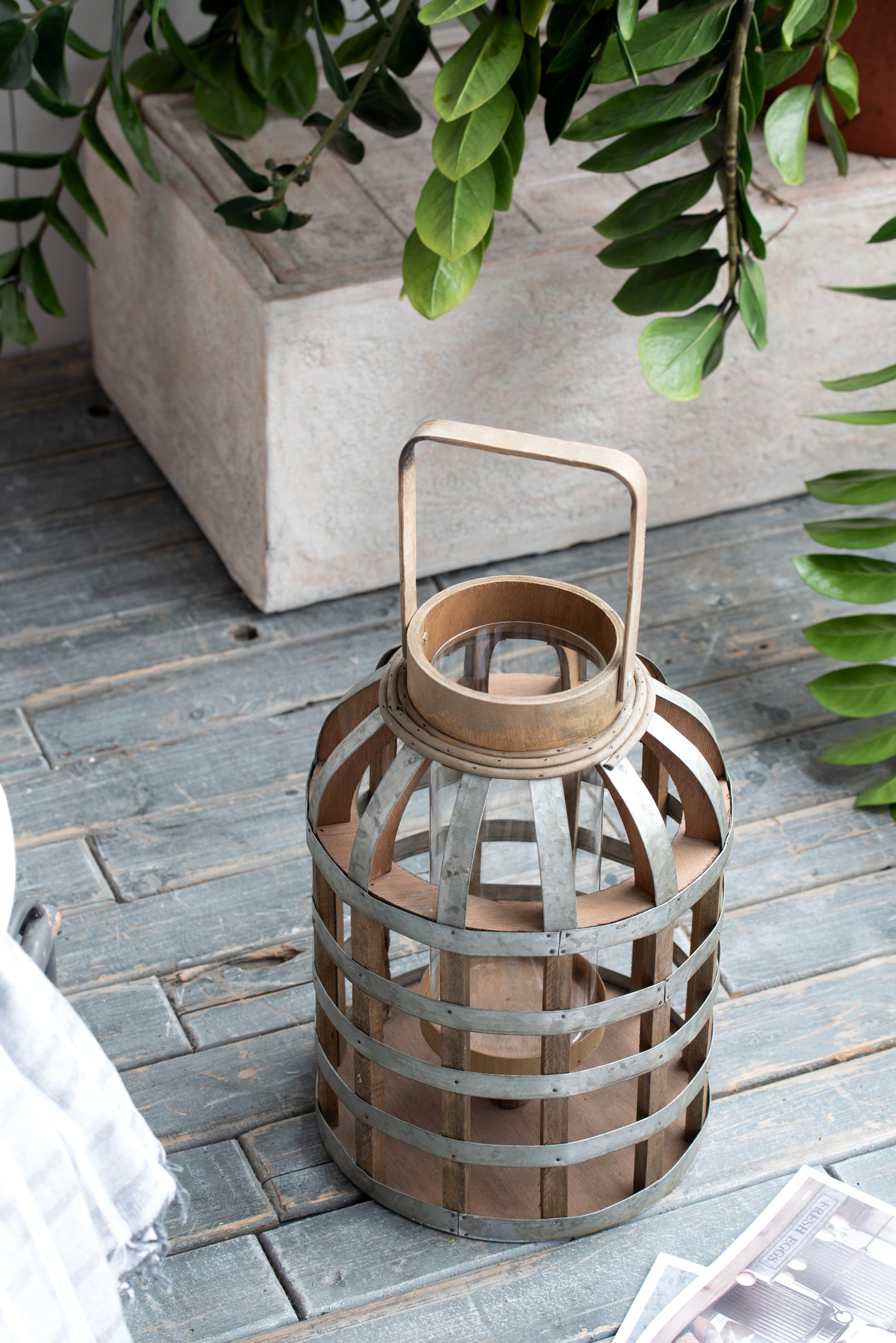Rustic wooden lantern with glass cylinder and metal banding for home decor