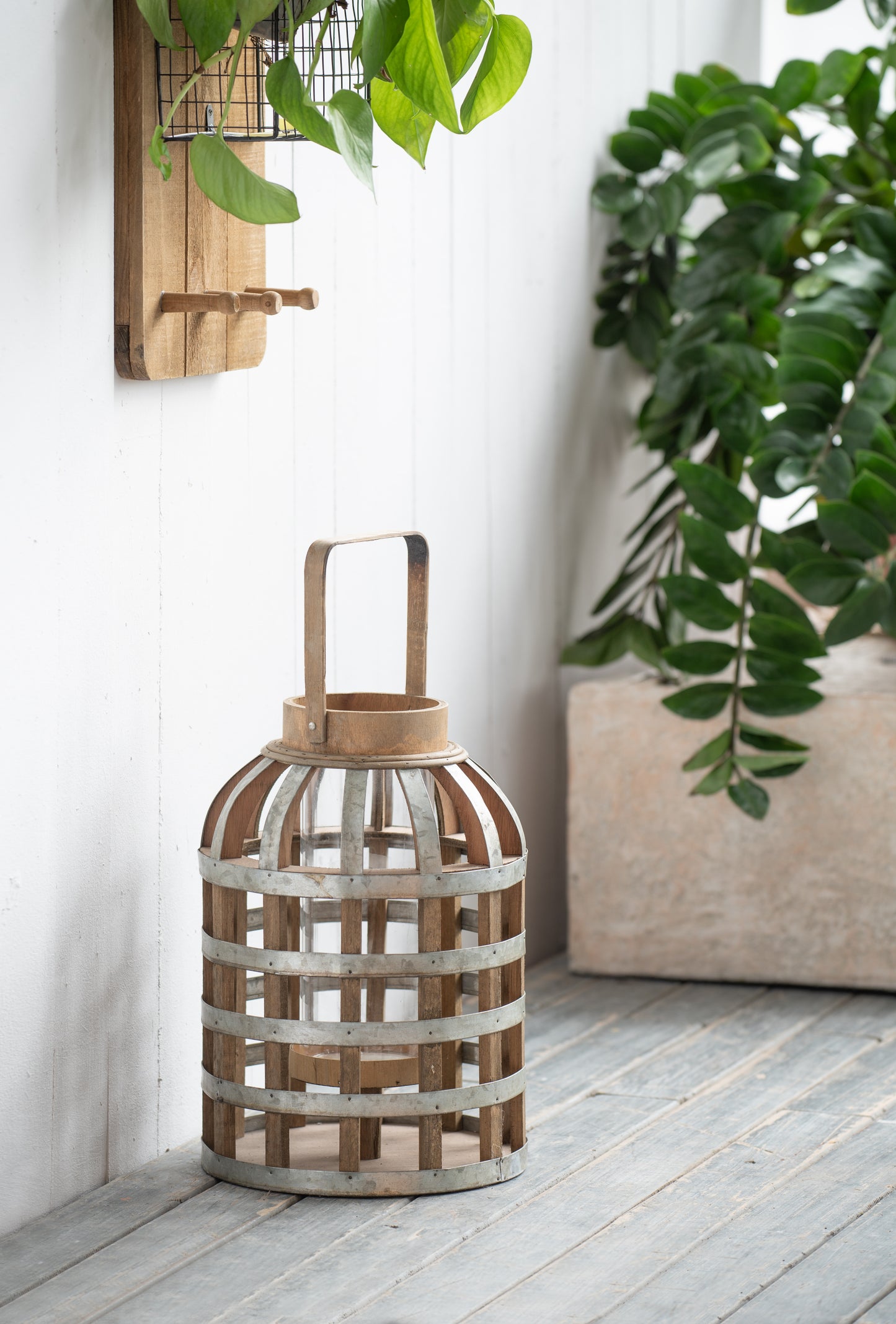 Rustic wooden lantern with metal banding and glass interior perfect for outdoor decor