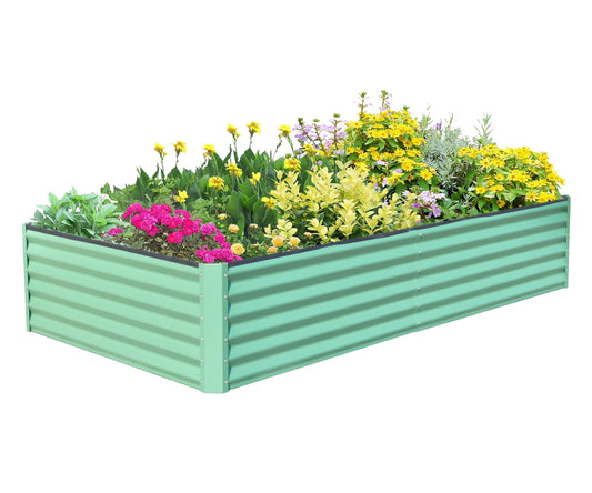 Rectangular mint green corrugated metal raised garden bed filled with colorful flowers and green foliage