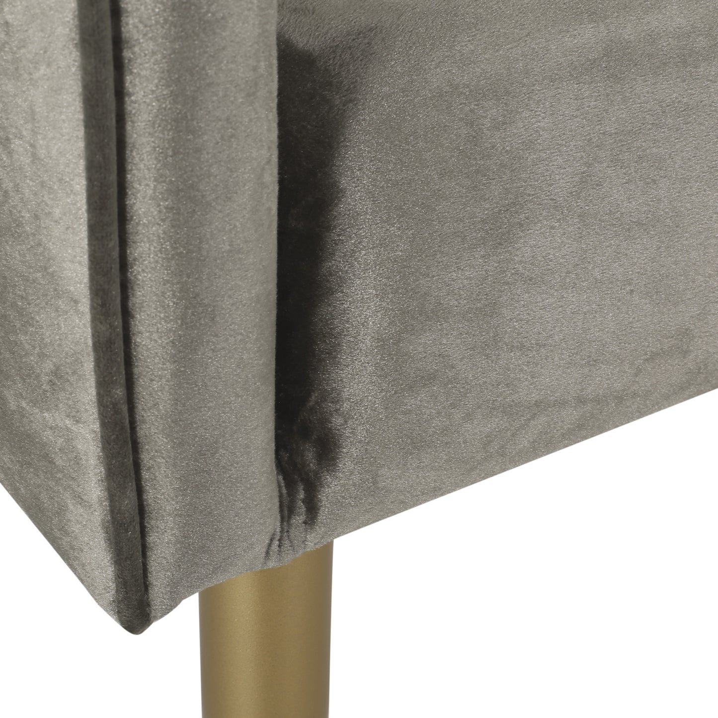 Closeup of plush grey velvet upholstery with a golden metal leg on a modern armchair