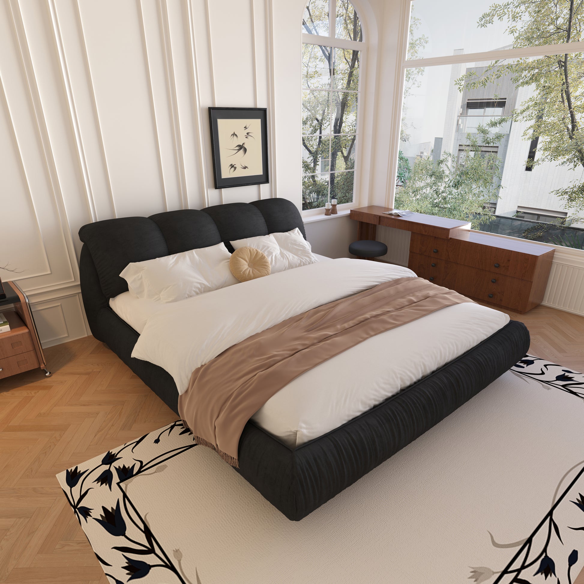 Black upholstered platform bed with white linens and a tan throw blanket