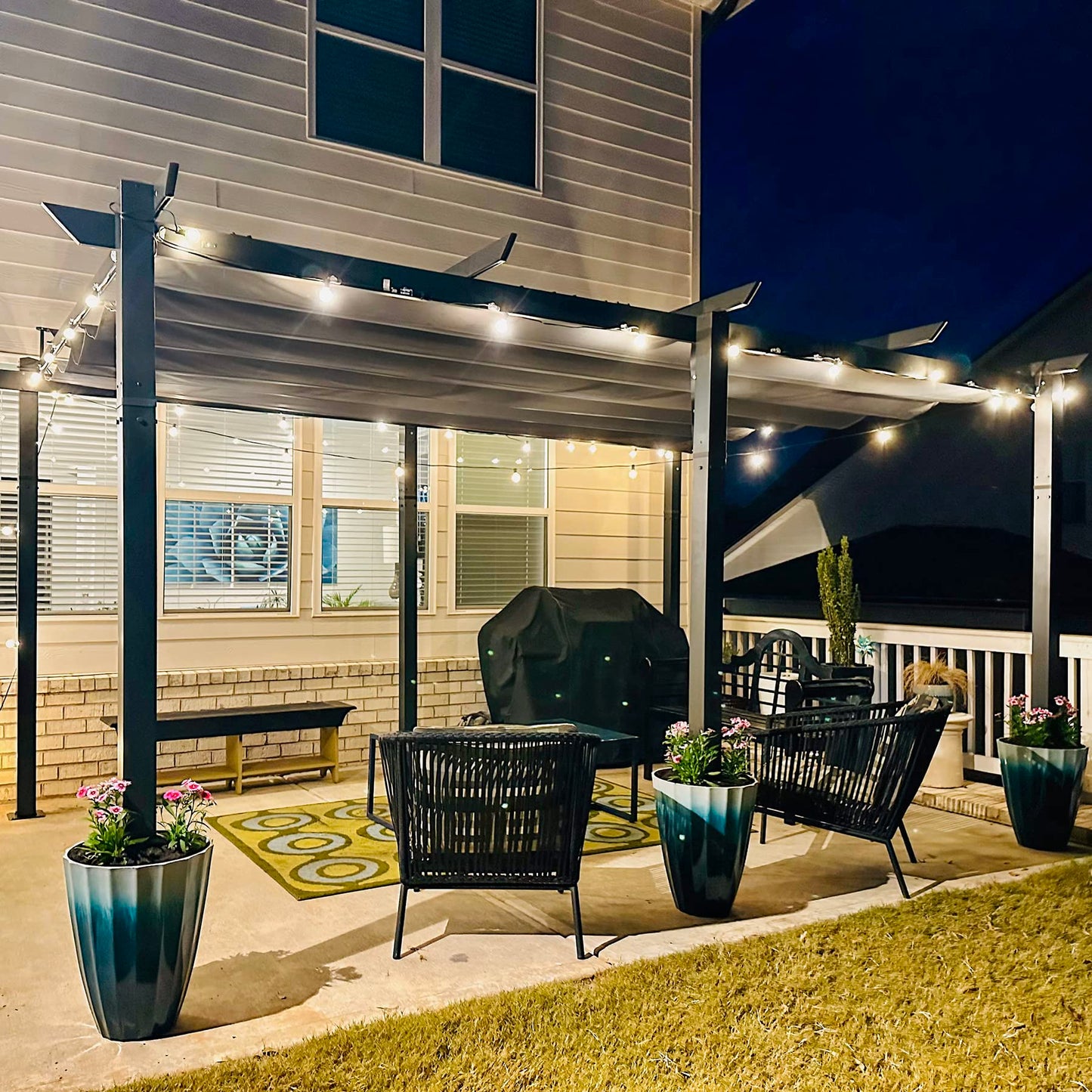 Modern outdoor patio pergola with string lights rattan chairs and planters
