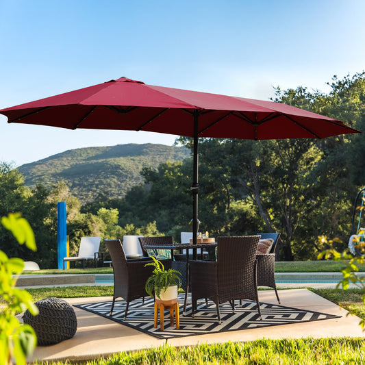 Dark red patio umbrella with a table and chairs set for outdoor dining