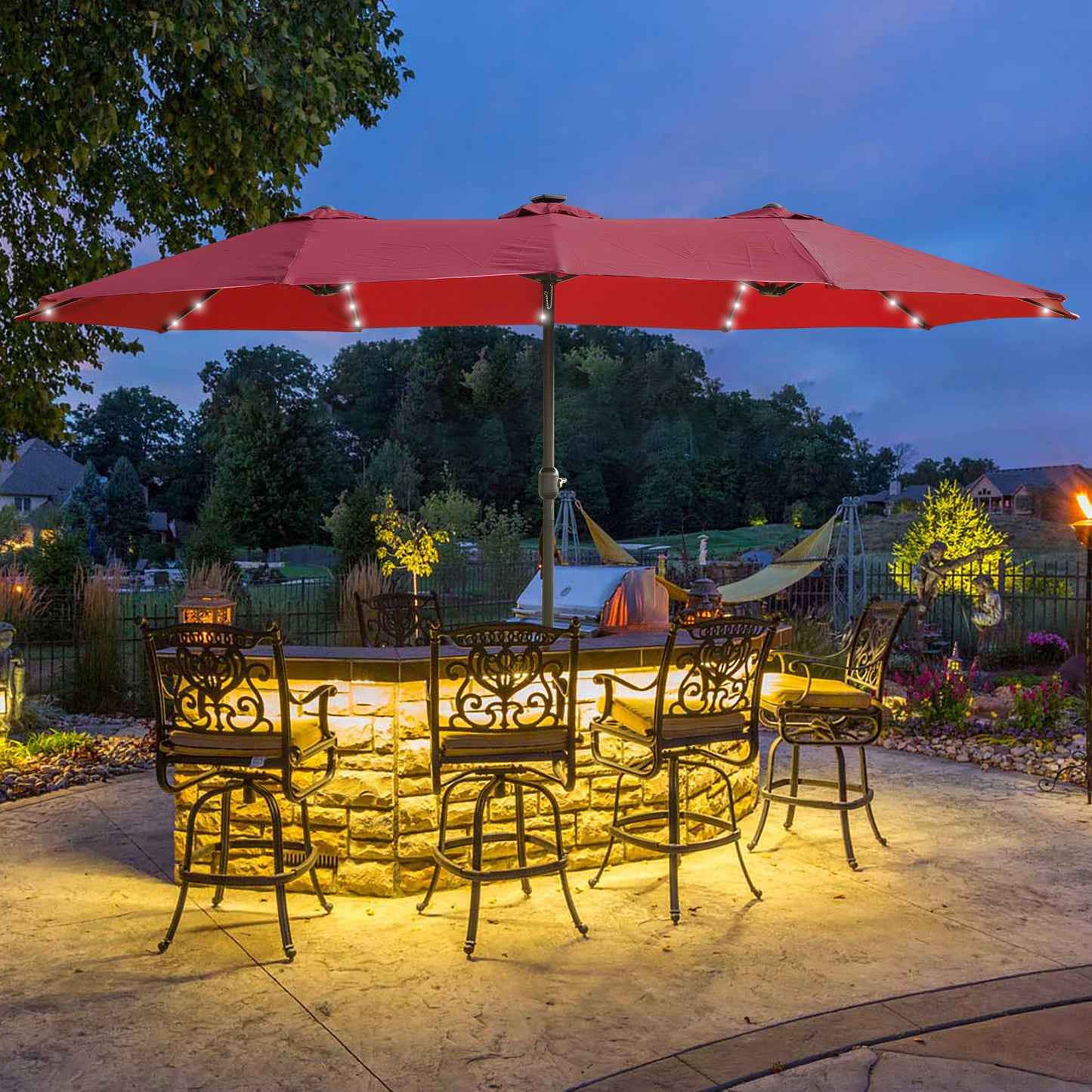Red patio umbrella with builtin solar lights over illuminated bar seating area
