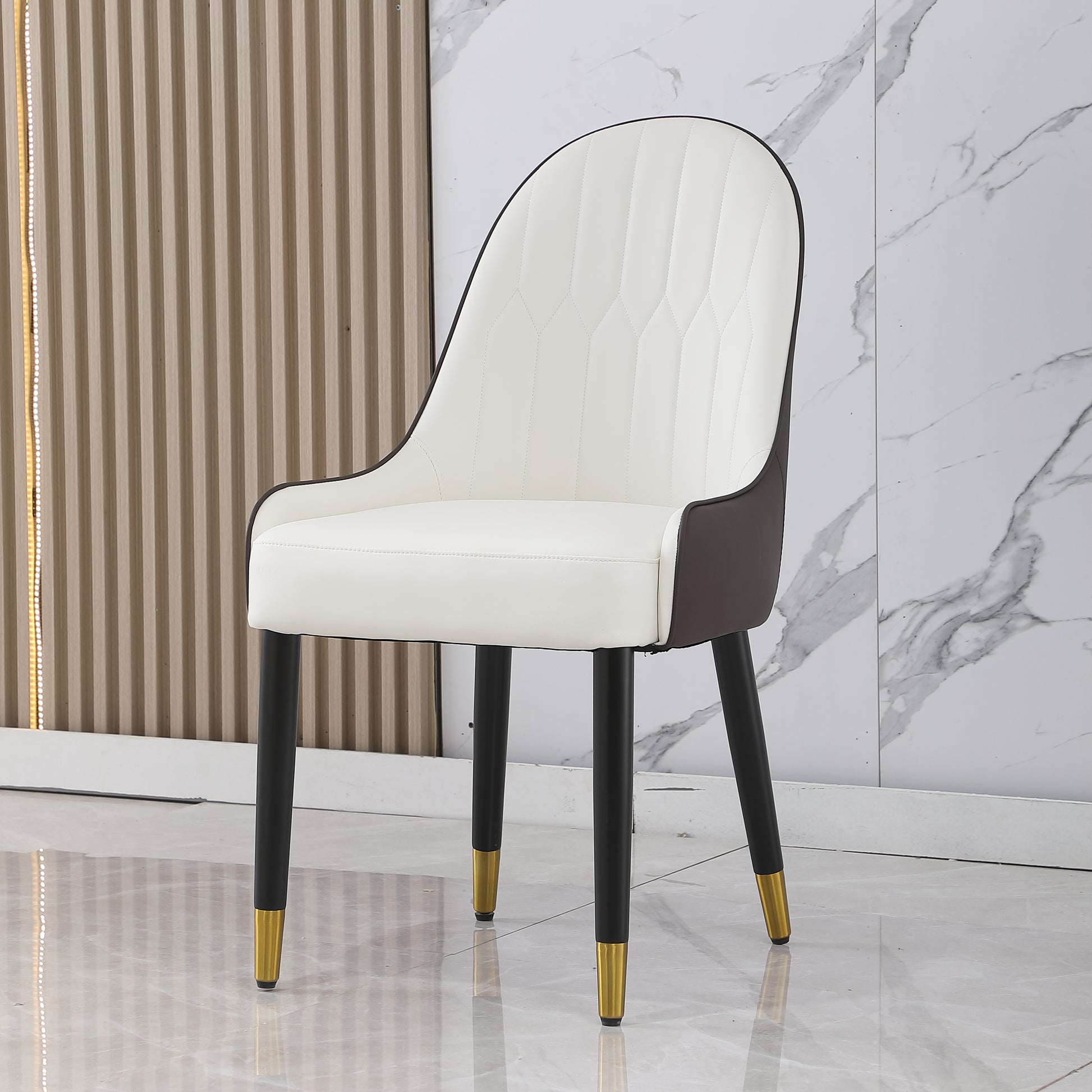 Elegant white upholstered dining chair with dark accents and goldtipped black legs