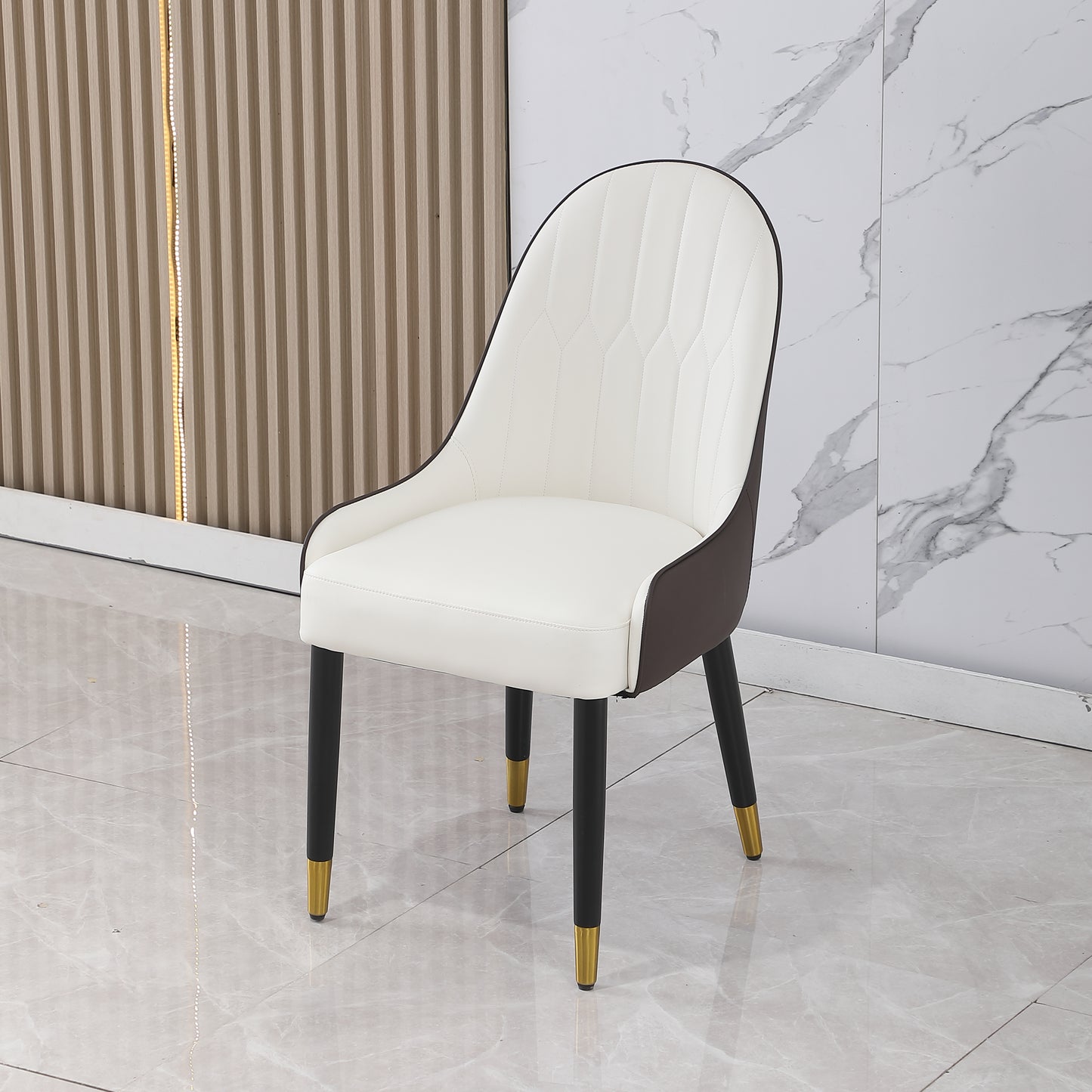 White upholstered dining chair with brown accents and goldtipped black legs