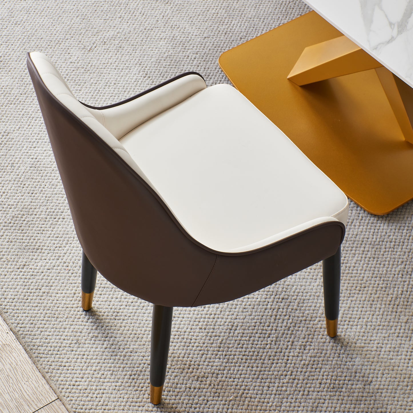 Modern upholstered dining chair with cream seat and brown leather back on dark legs