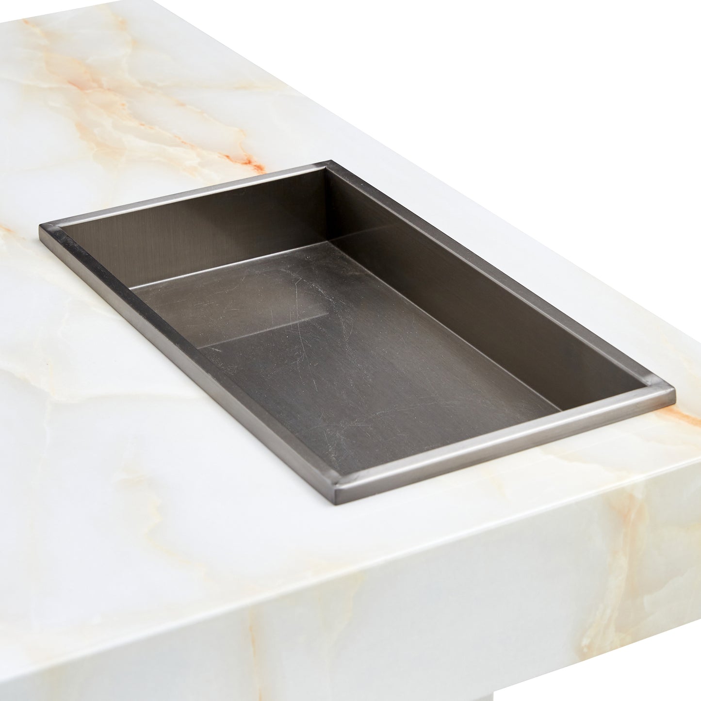 Stainless steel sink insert set into a white marble countertop with subtle gold veining