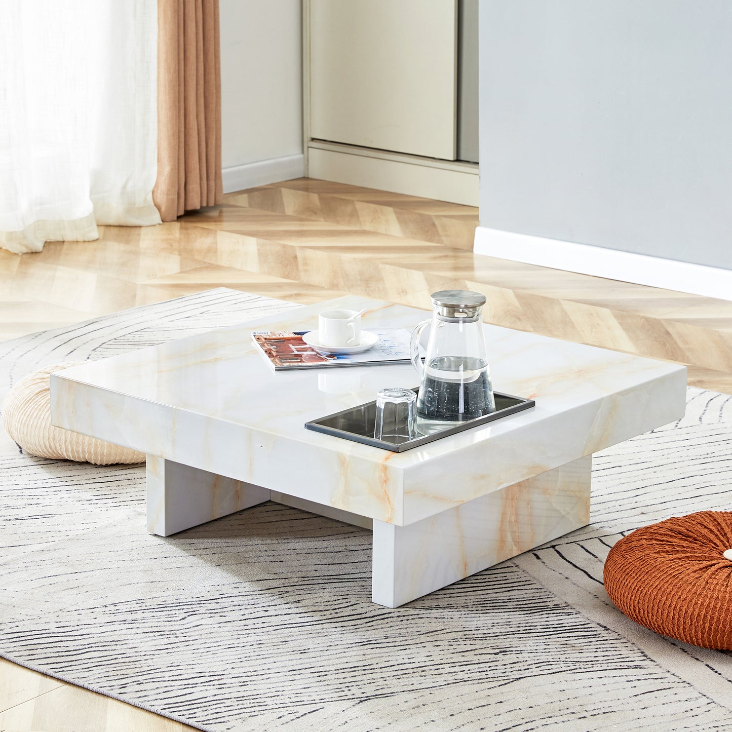 Square white marble coffee table with modern marble veining and metal tray with carafe