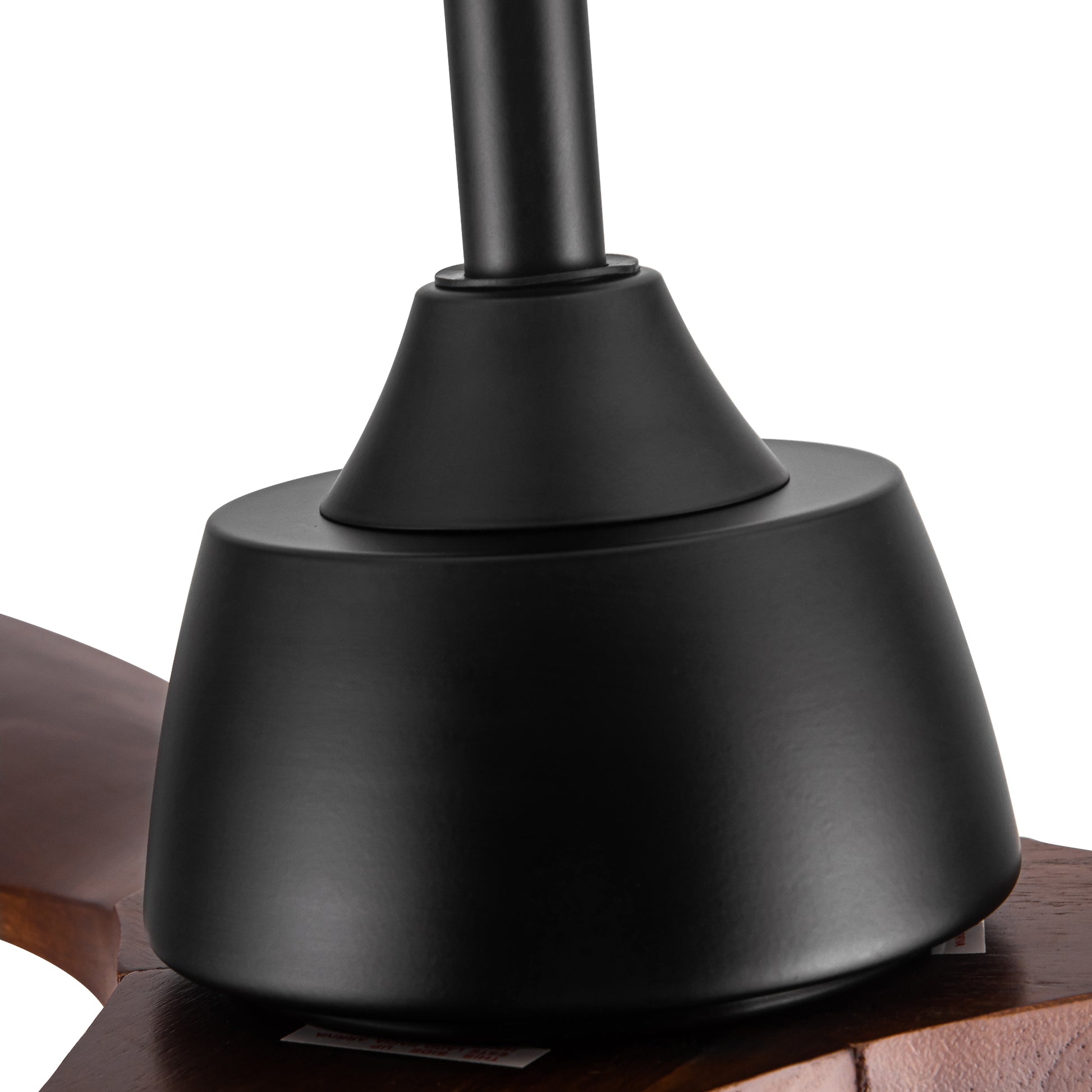 Closeup of matte black ceiling fan motor housing and dark wood blade connection