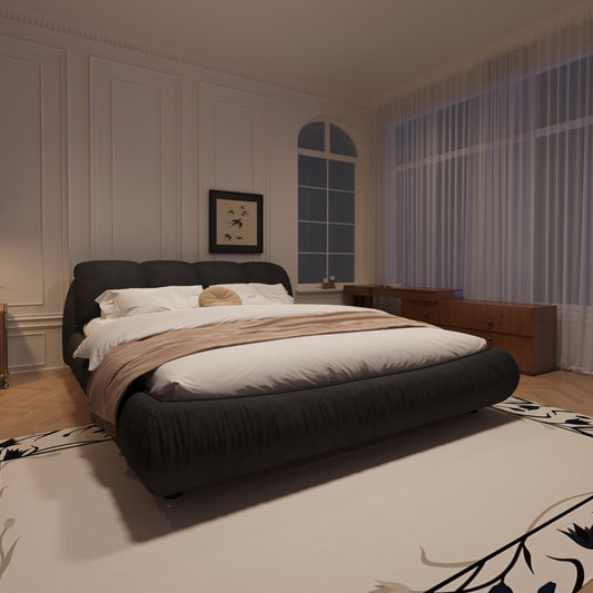 Dark upholstered platform bed with white bedding and tan throw