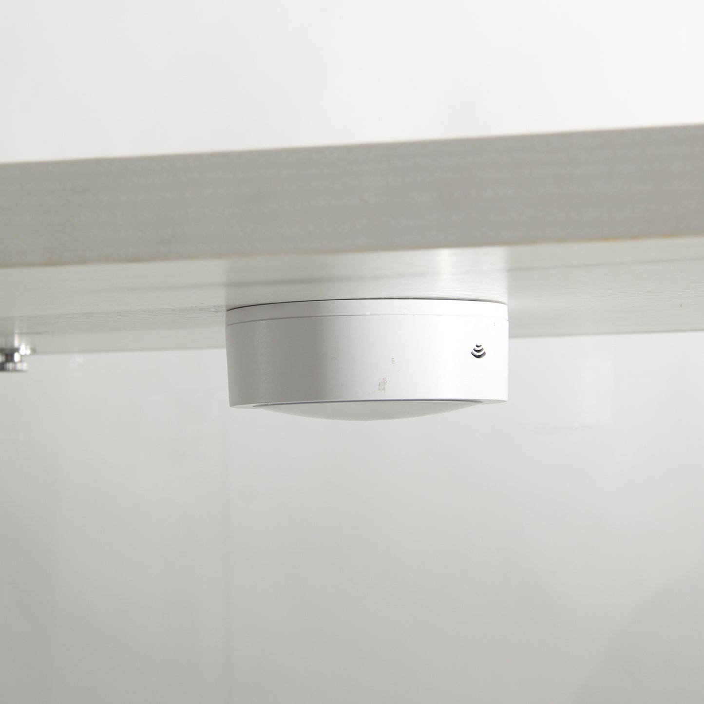 White smart hub with WiFi symbol mounted under a desk for connectivity