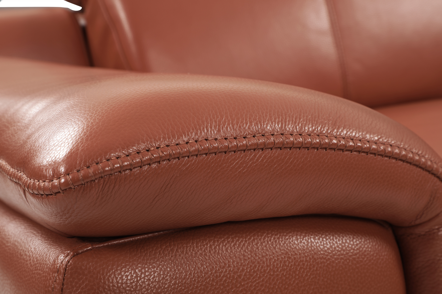 Brown leather armchair armrest detail with stitching