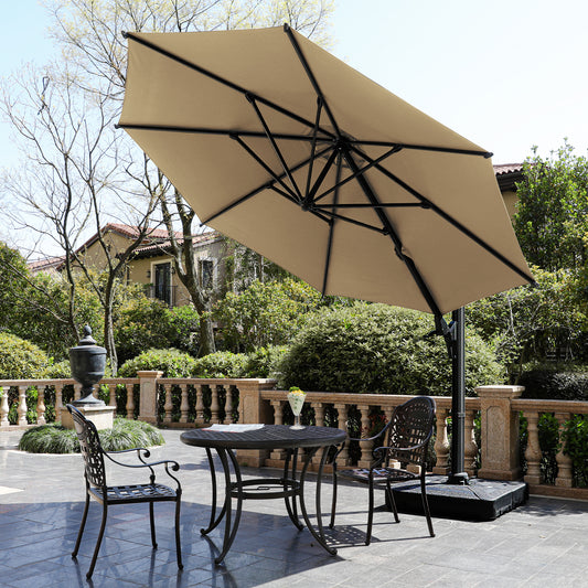 Large tan cantilever umbrella with ornate metal patio chairs and table set