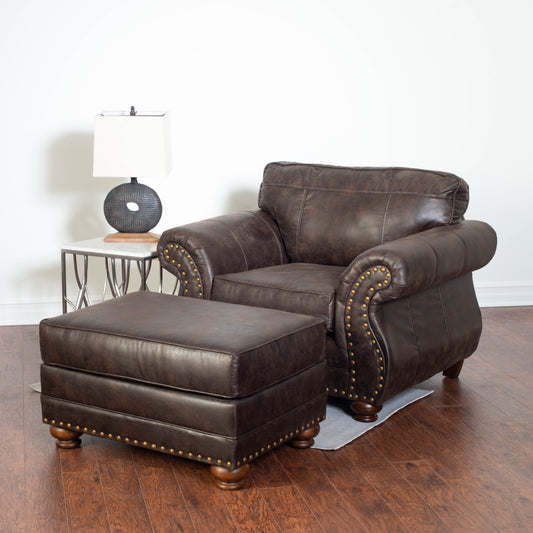 Distressed brown leather armchair with brass nailhead trim and matching ottoman
