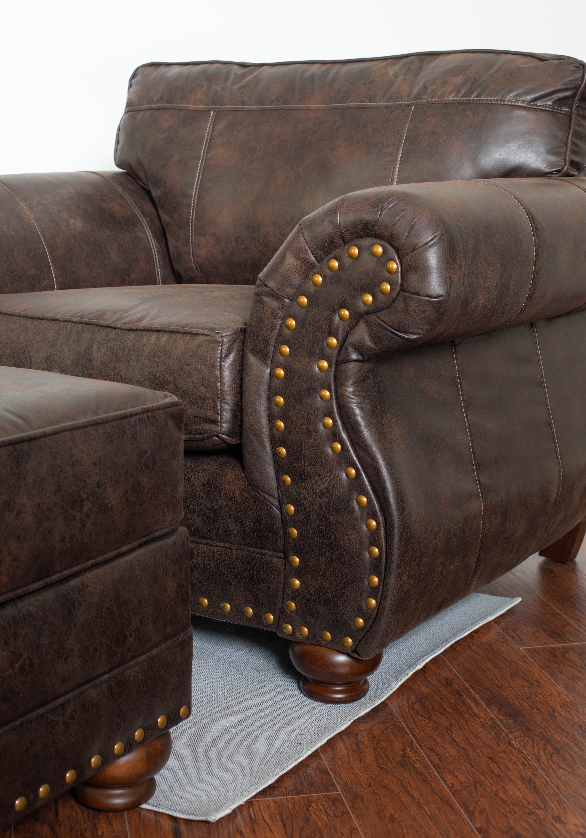 Rich brown leather recliner with ornate brass nailhead trim and plush cushioning