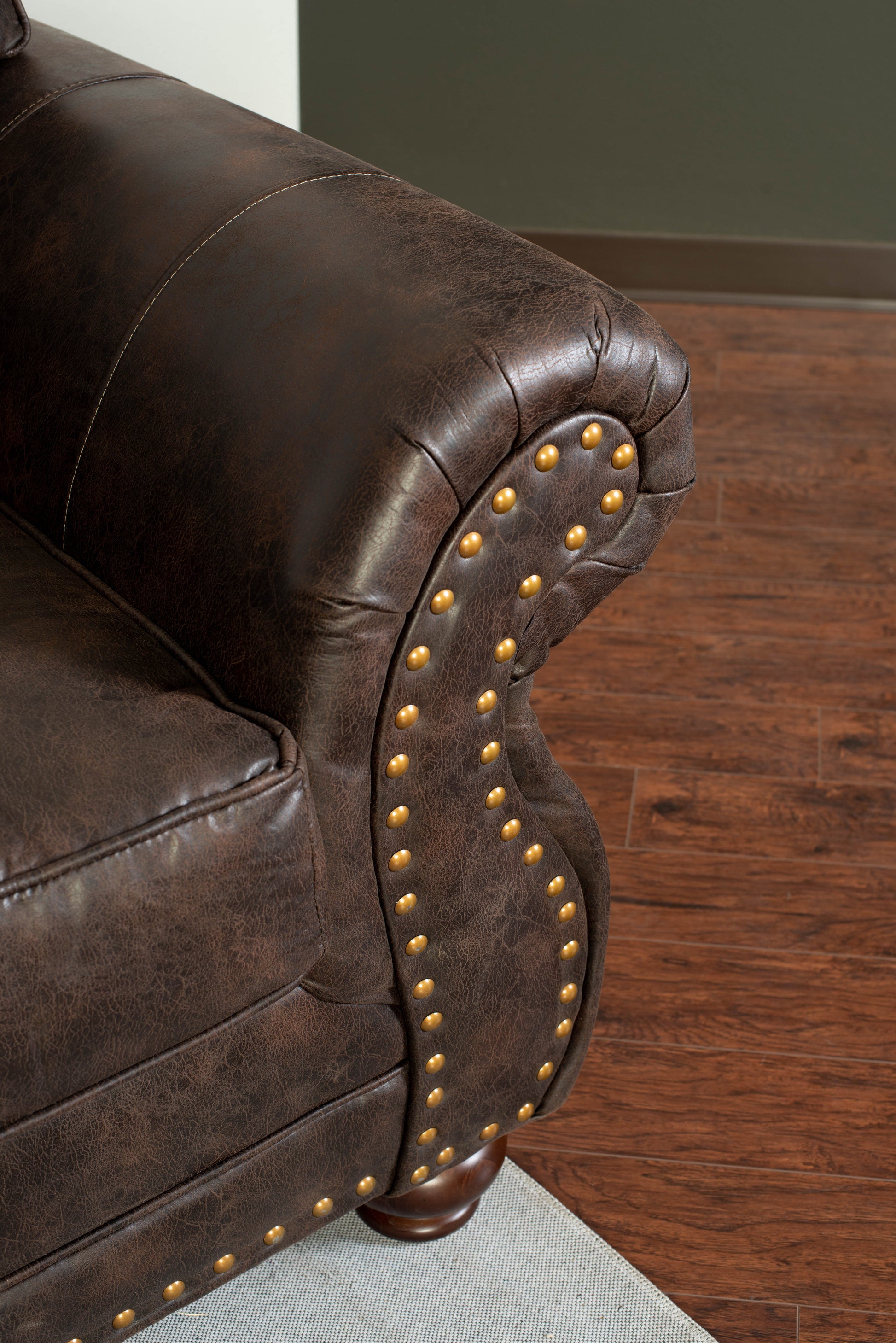 Dark brown leather chesterfield sofa armrest with brass nailhead trim