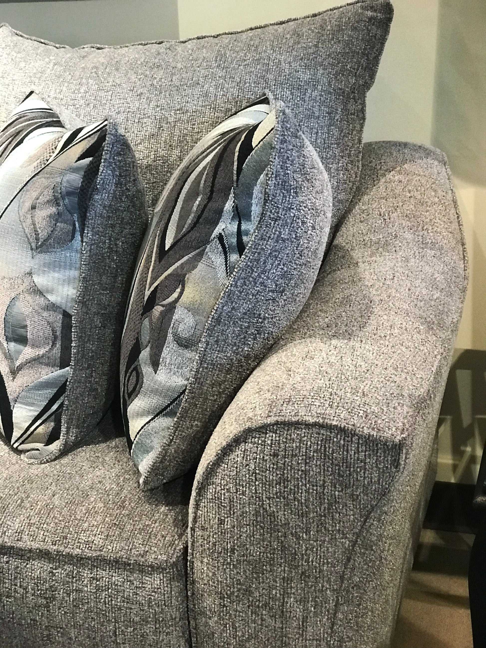Grey textured sofa with abstract leaf pattern accent pillows for comfortable living room decor