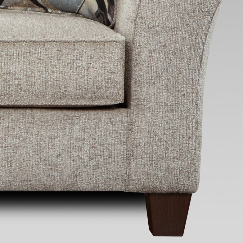 Closeup of textured beige fabric on a sofa armrest and seat cushion