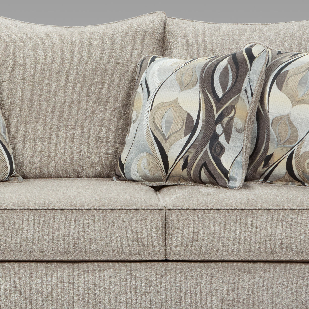 Tan textured fabric sofa with abstract patterned throw pillows