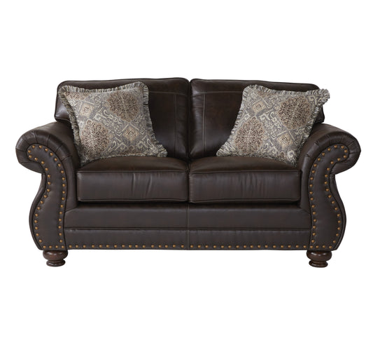 Dark brown leather loveseat with ornate patterned throw pillows and brass nailhead trim