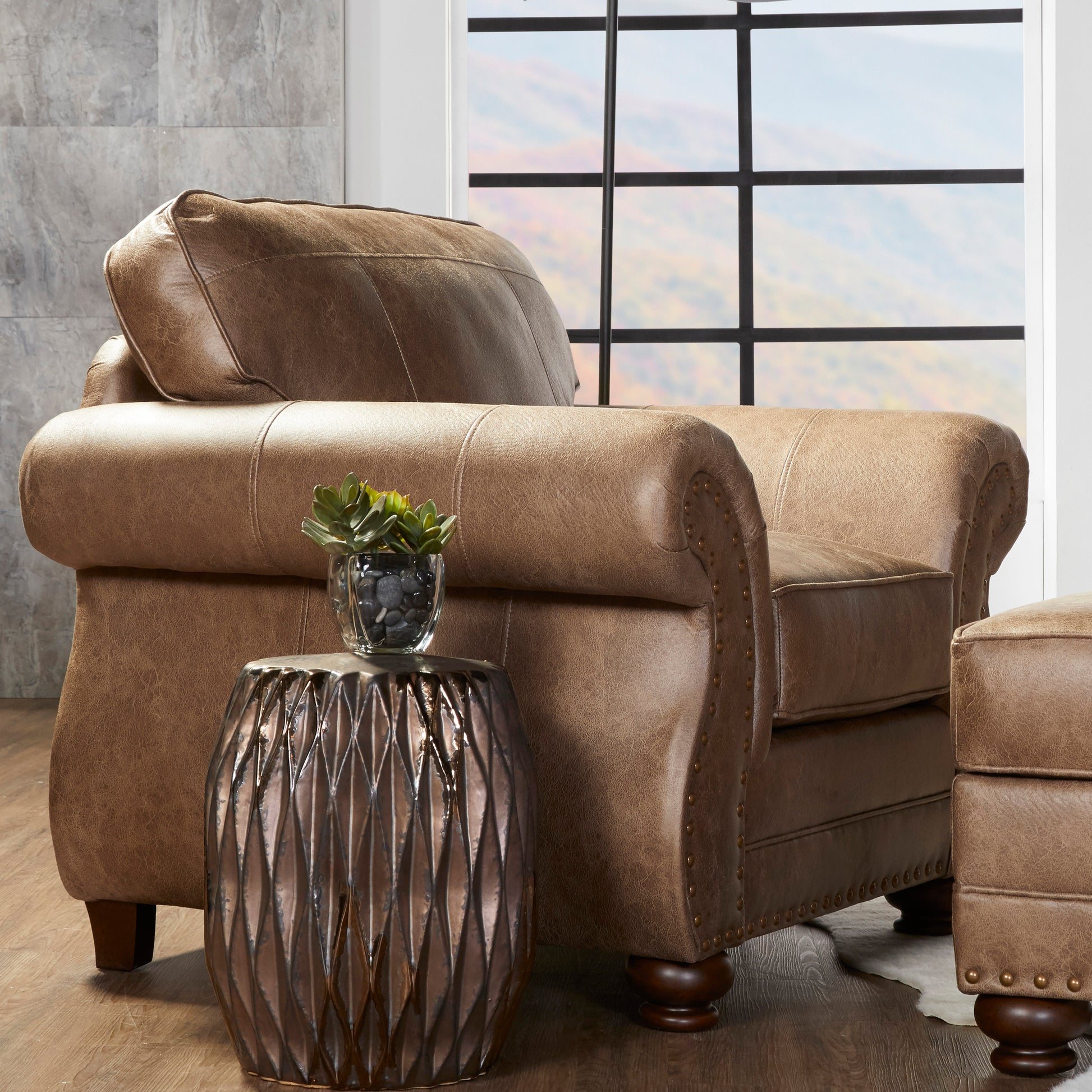 Brown leather armchair with plush cushions and decorative nailhead trim perfect for living room seating