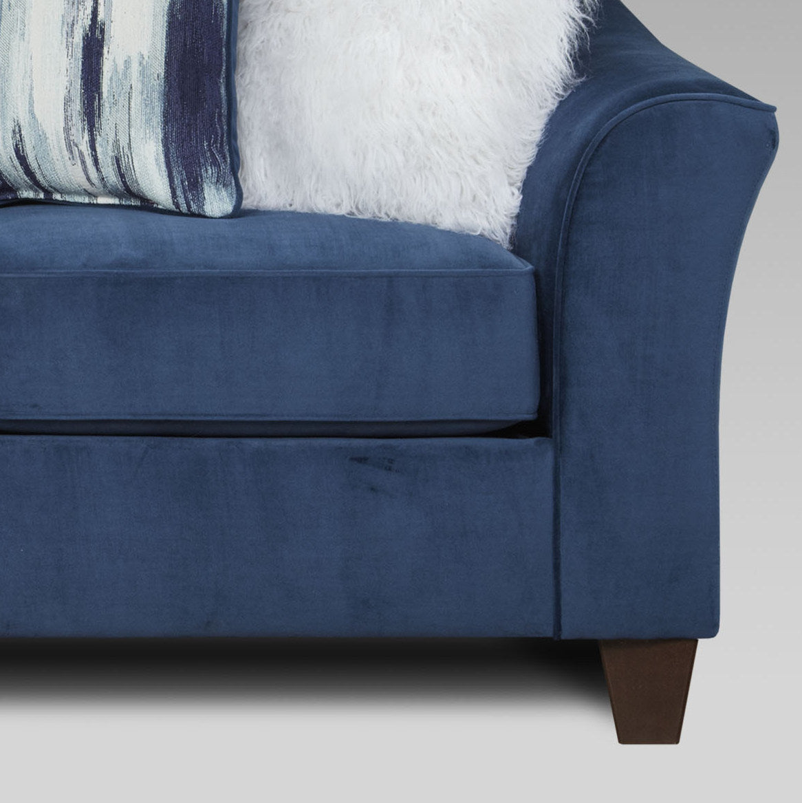 Deep navy velvet sofa with plush throw pillows and clean lines perfect for modern living rooms