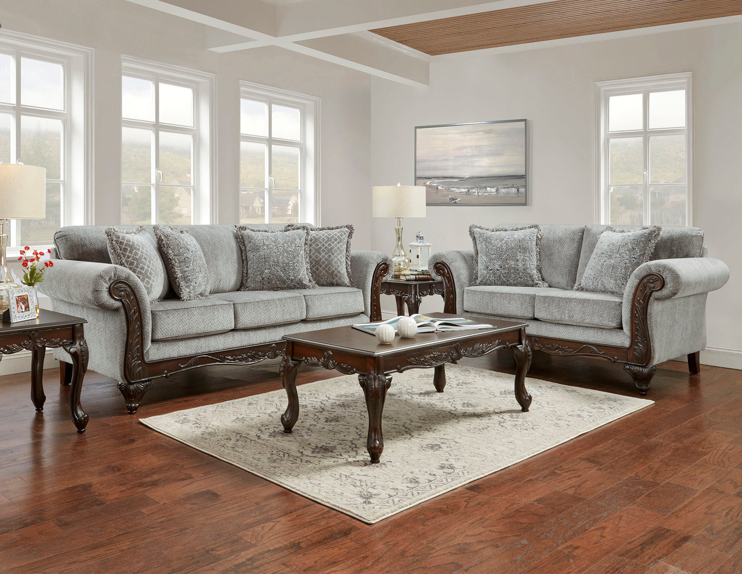 Luxurious grey fabric sofa with ornate dark wood accents and patterned throw pillows for elegant living room seating