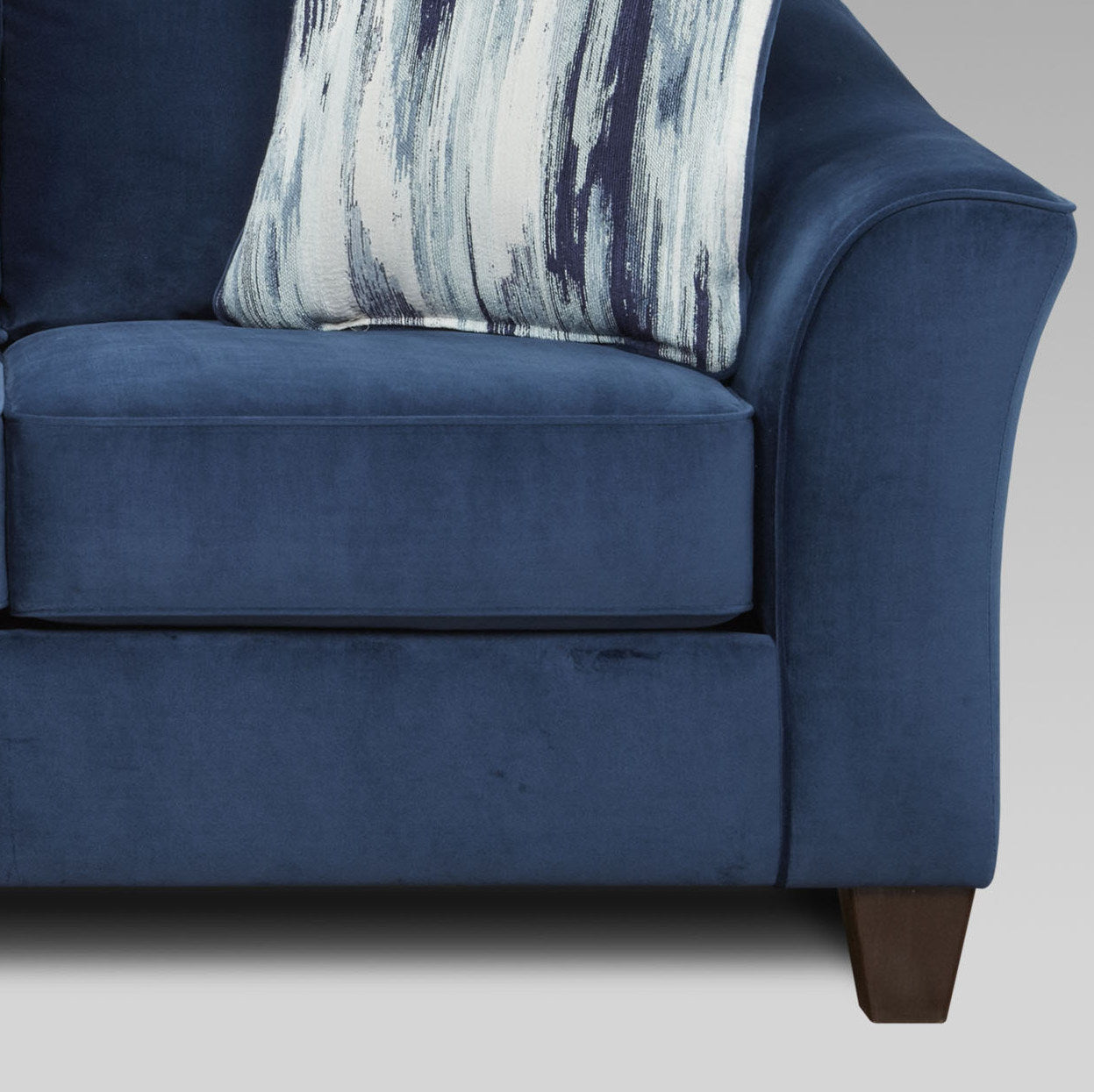 Deep navy velvet sofa with plush cushions and an abstract patterned throw pillow