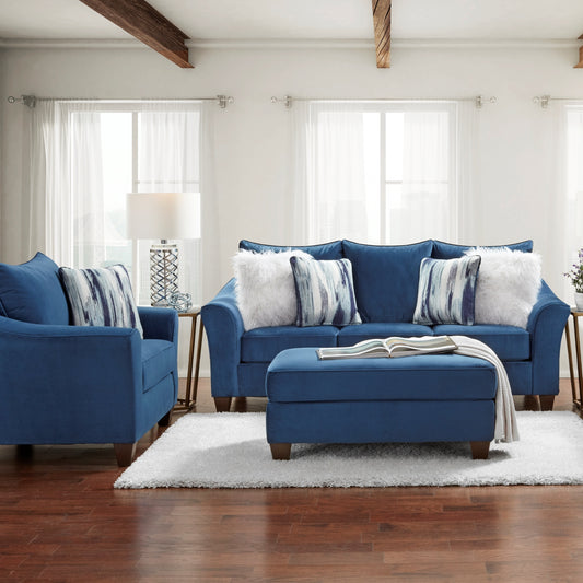 Deep blue velvet sofa with decorative pillows and matching ottoman