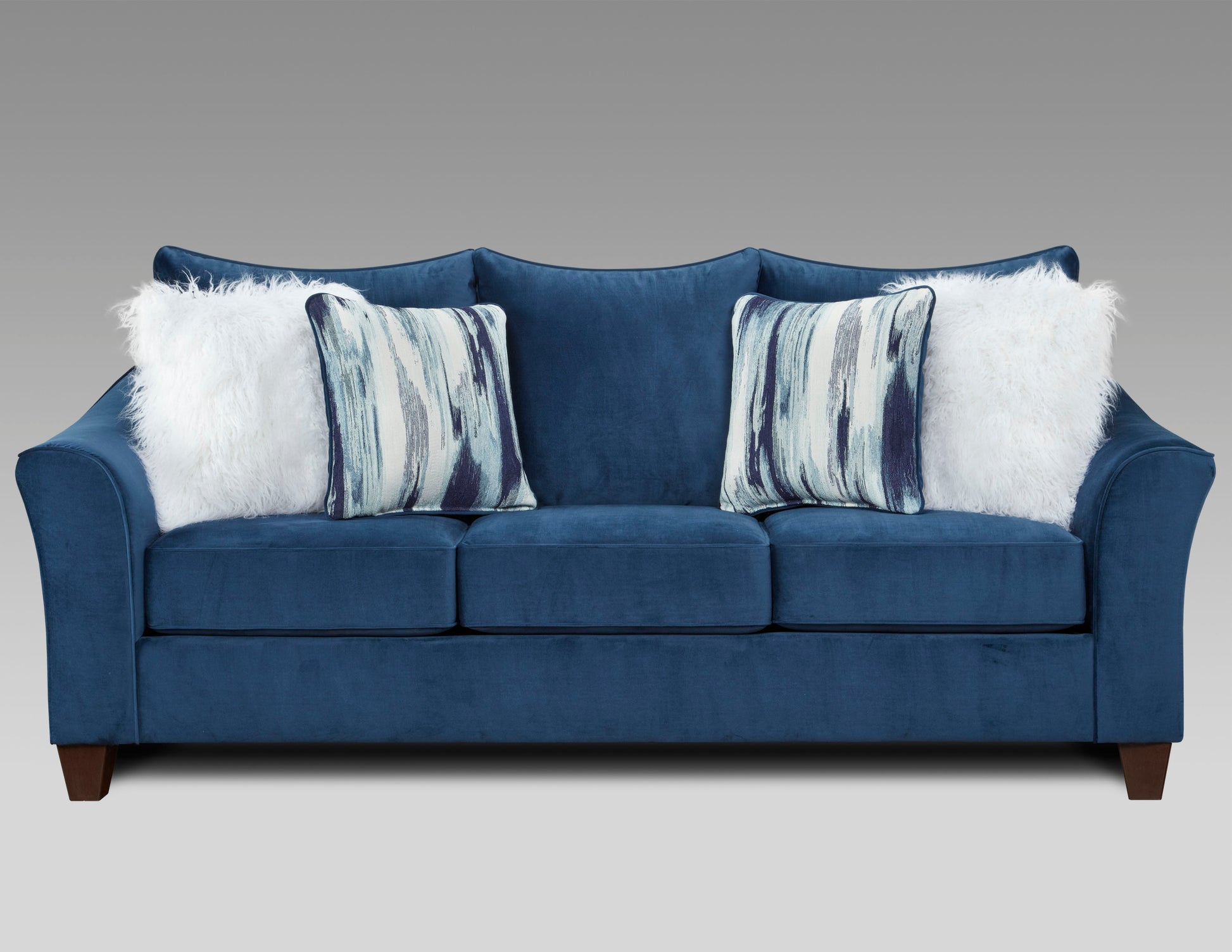 Deep blue velvet sofa with abstract pattern pillows and white faux fur pillows