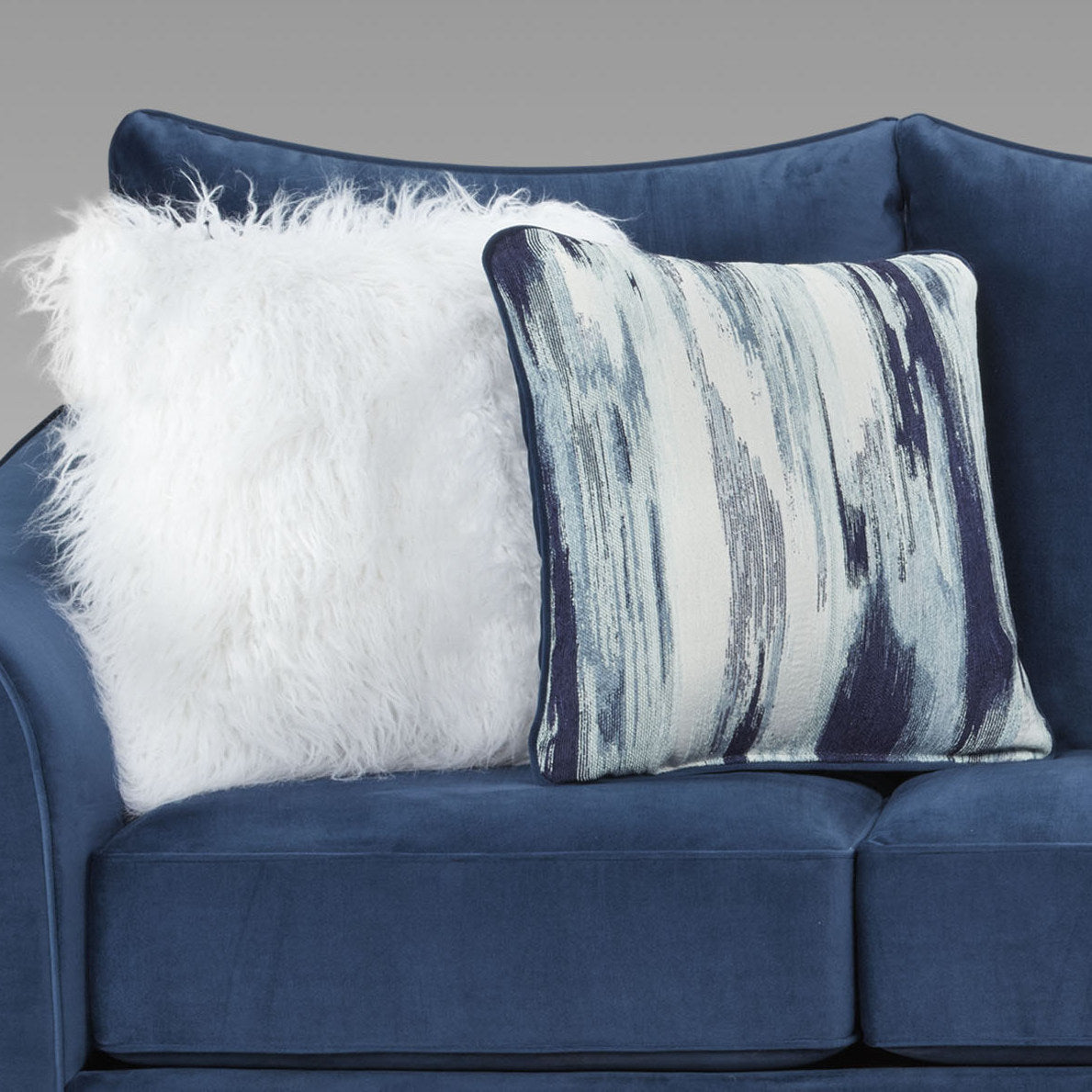 Fluffy white throw pillow on a blue velvet sofa adding cozy texture