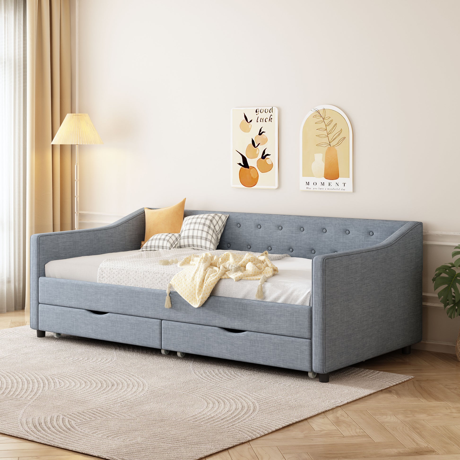 Blue upholstered daybed with button tufting and two pullout storage drawers