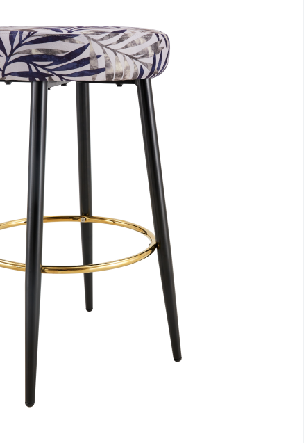 Round bar stool with upholstered seat in botanical leaf print and black legs with gold footrest
