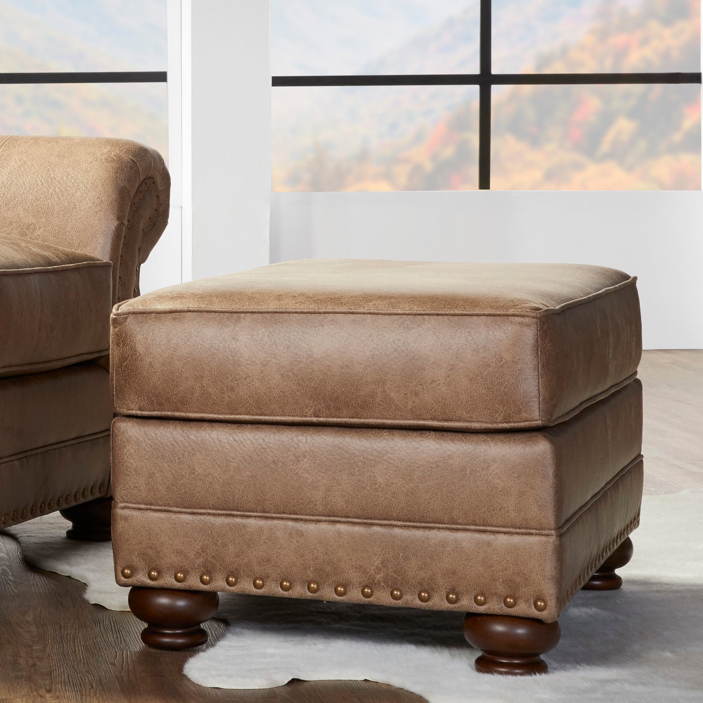 Tufted brown leather ottoman with nailhead trim and dark wood legs perfect for a living room accent
