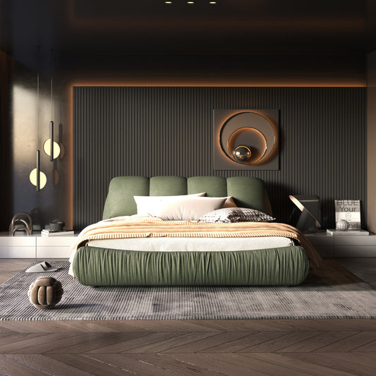 Modern upholstered green bed with plush bedding and accent pillows