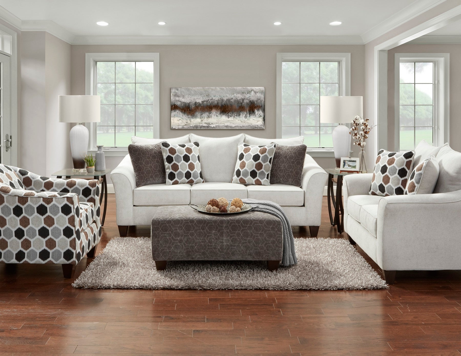 White sofa with patterned accent pillows and a hexagonal armchair