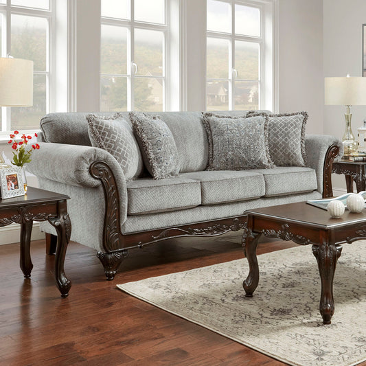 Elegant gray fabric sofa with ornate dark wood trim and decorative pillows