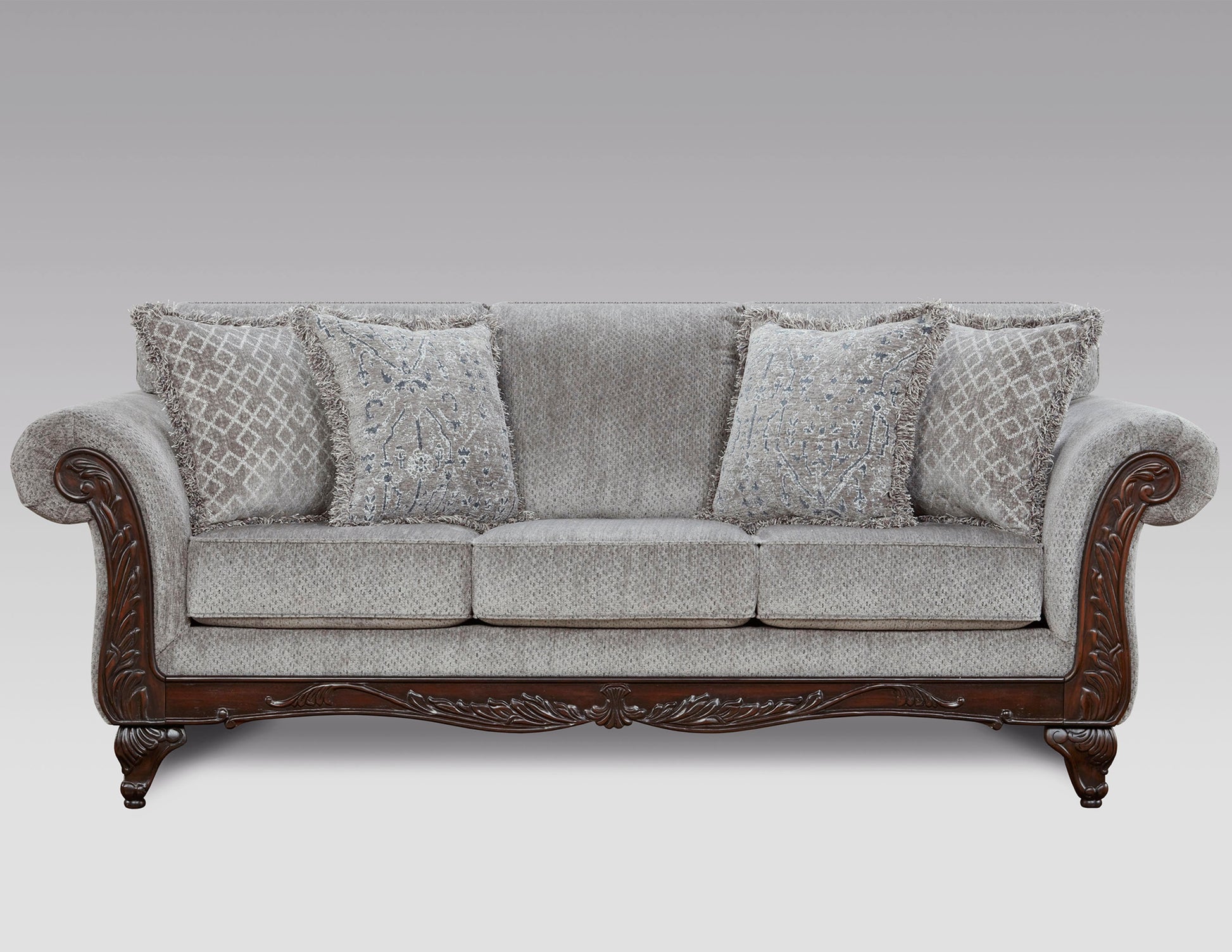 Elegant grey upholstered sofa with intricately carved dark wood frame and decorative pillows
