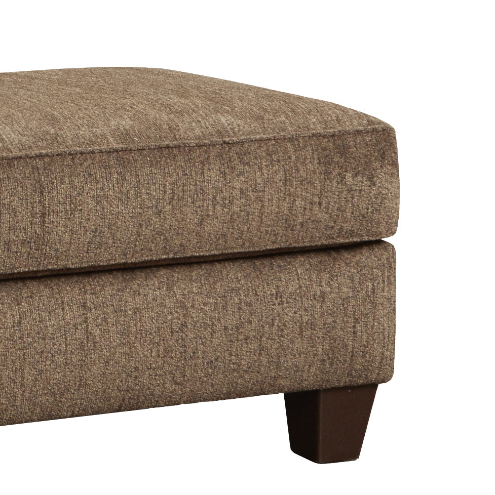 Closeup of a textured brown fabric ottoman with a dark wood leg