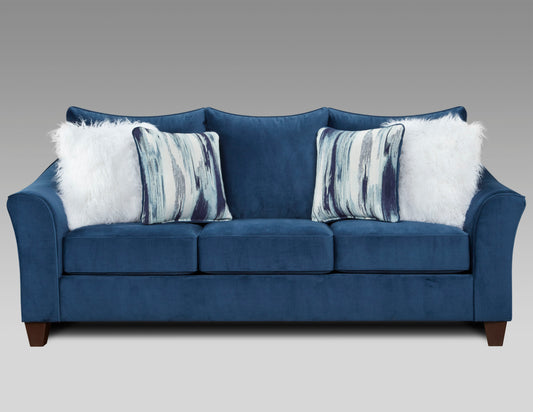 Deep blue velvet sofa with plush white and striped accent pillows