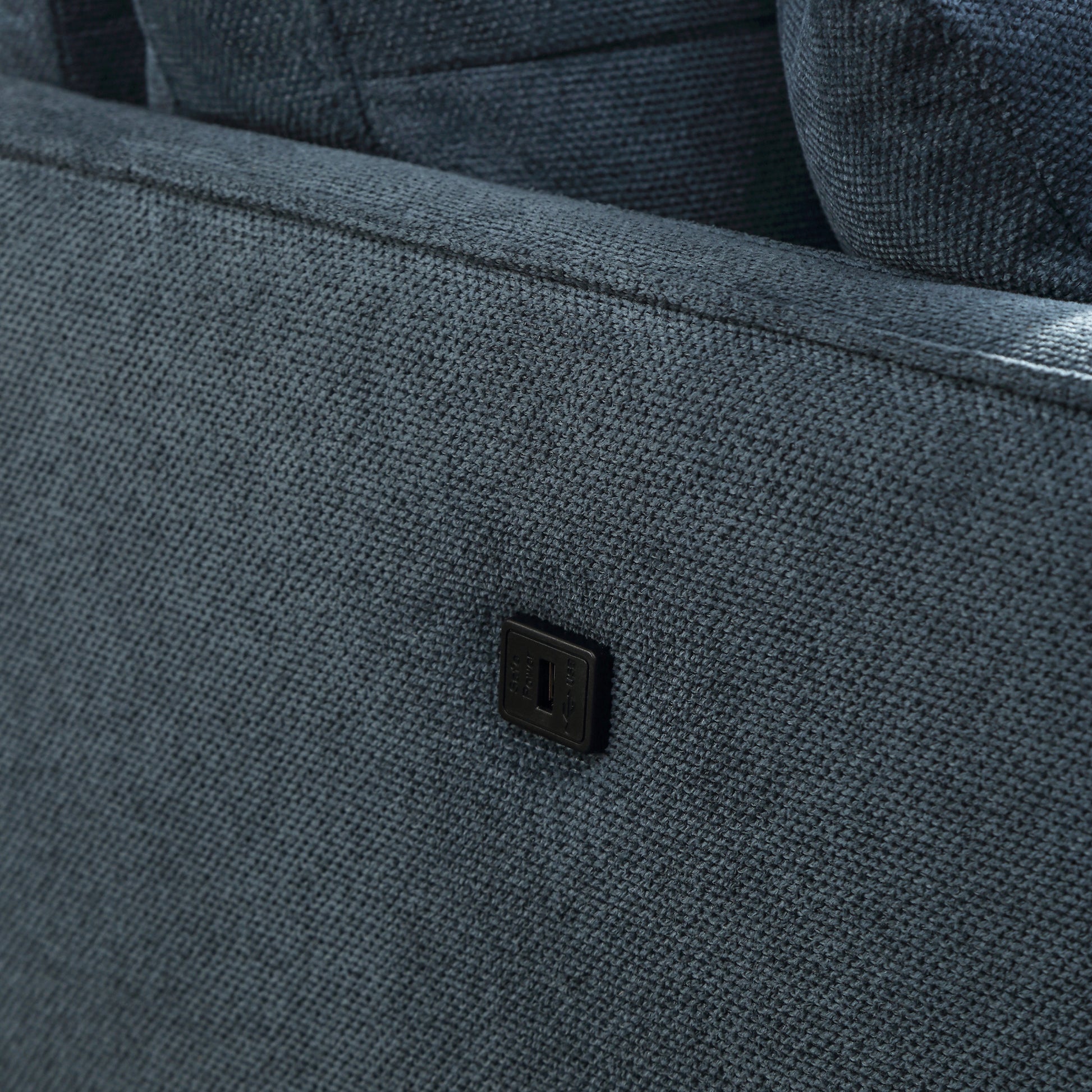 Dark grey fabric sofa with integrated USB power port for charging devices
