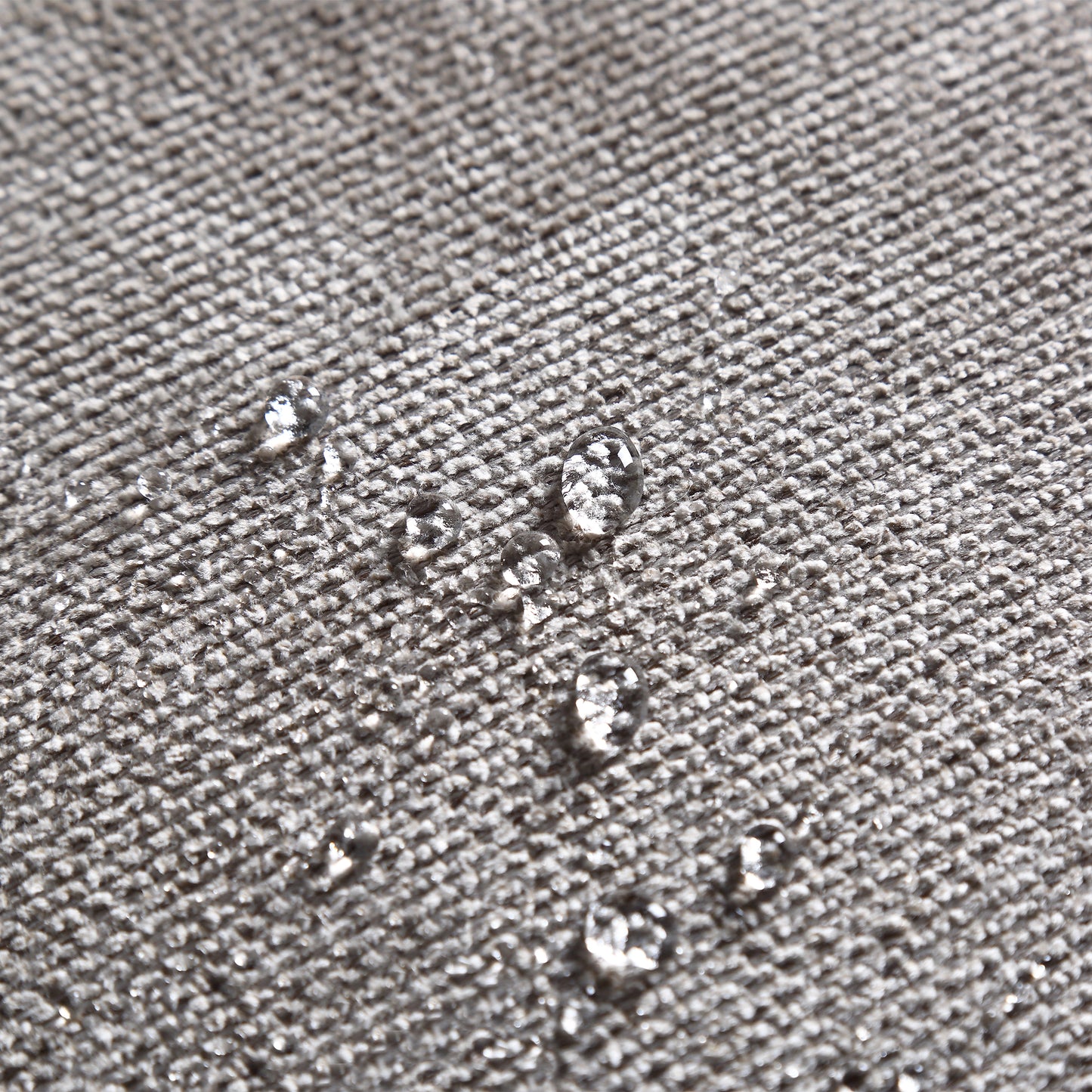 Closeup of grey textured fabric with water beads showcasing its waterrepellent coating