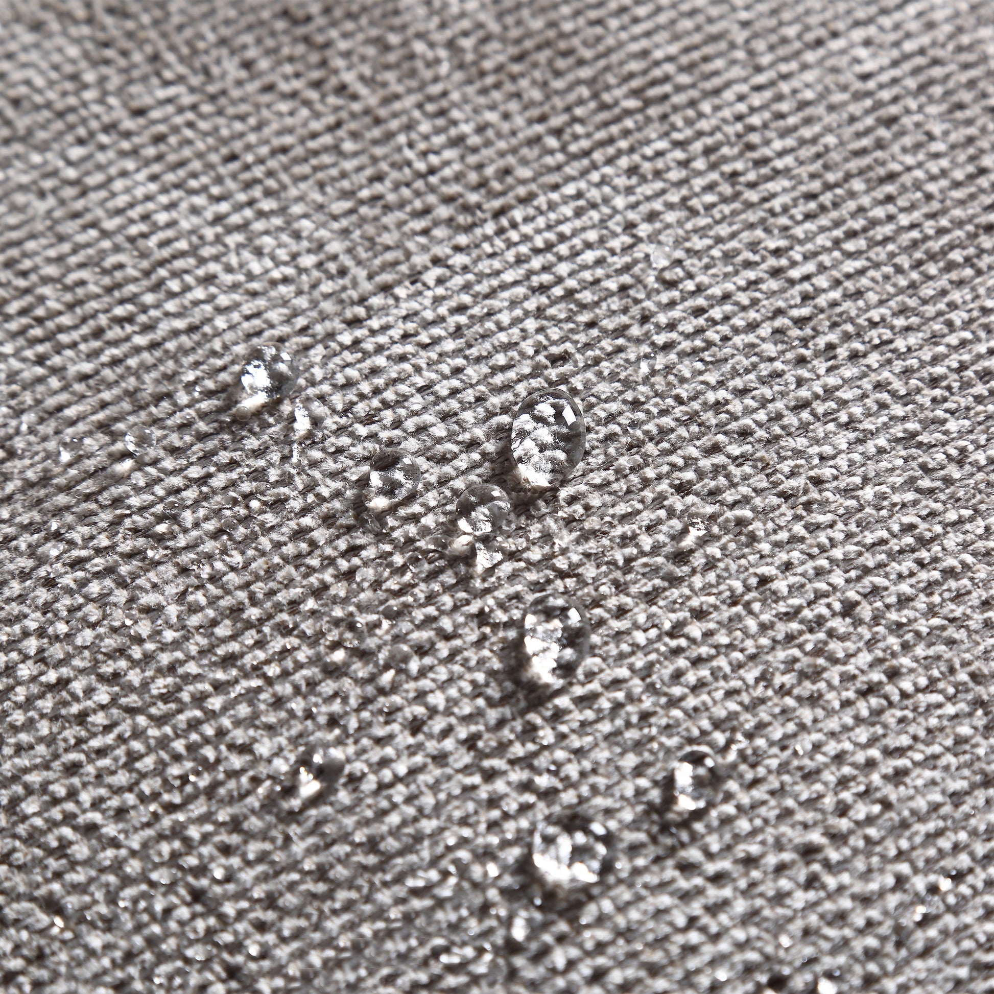 Closeup of grey textured fabric with water beads showcasing its waterrepellent coating
