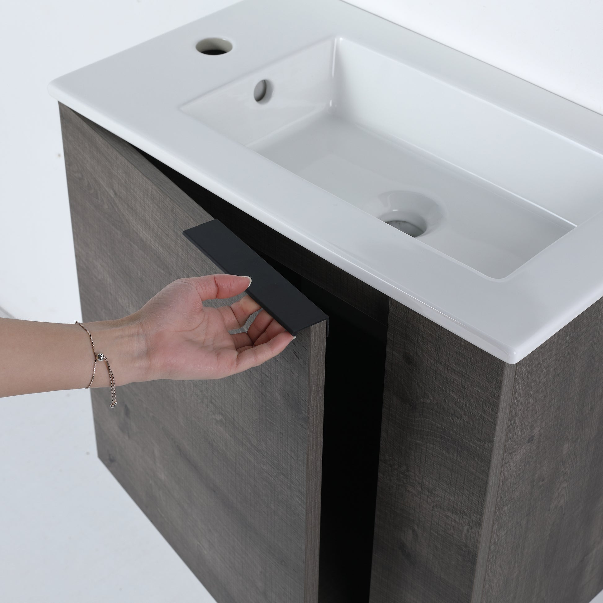 Modern grey wood bathroom vanity with integrated white ceramic sink and black handle