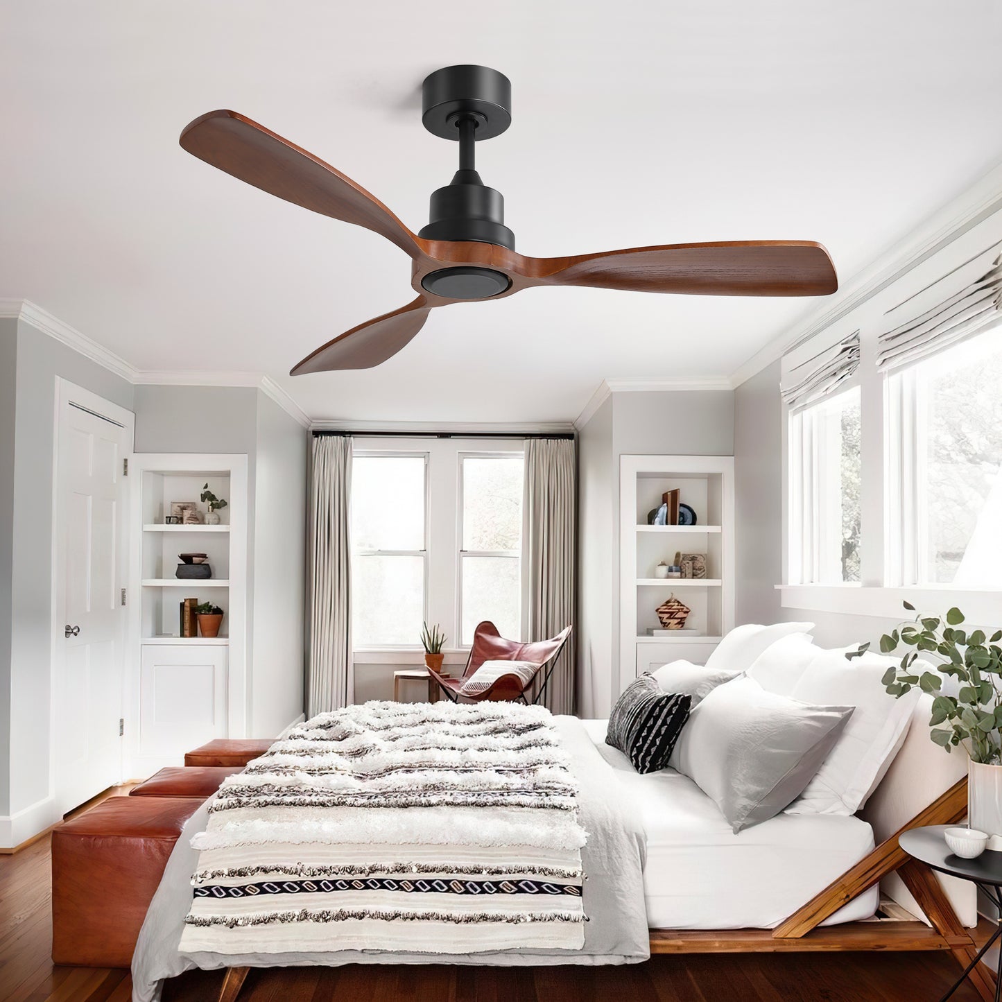 Modern black ceiling fan with three natural wood blades in a bedroom