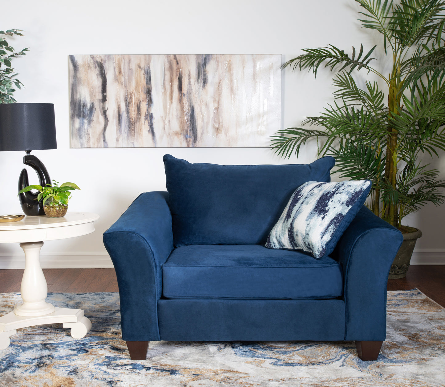 Plush navy blue armchair with tapered wooden legs and a decorative throw pillow